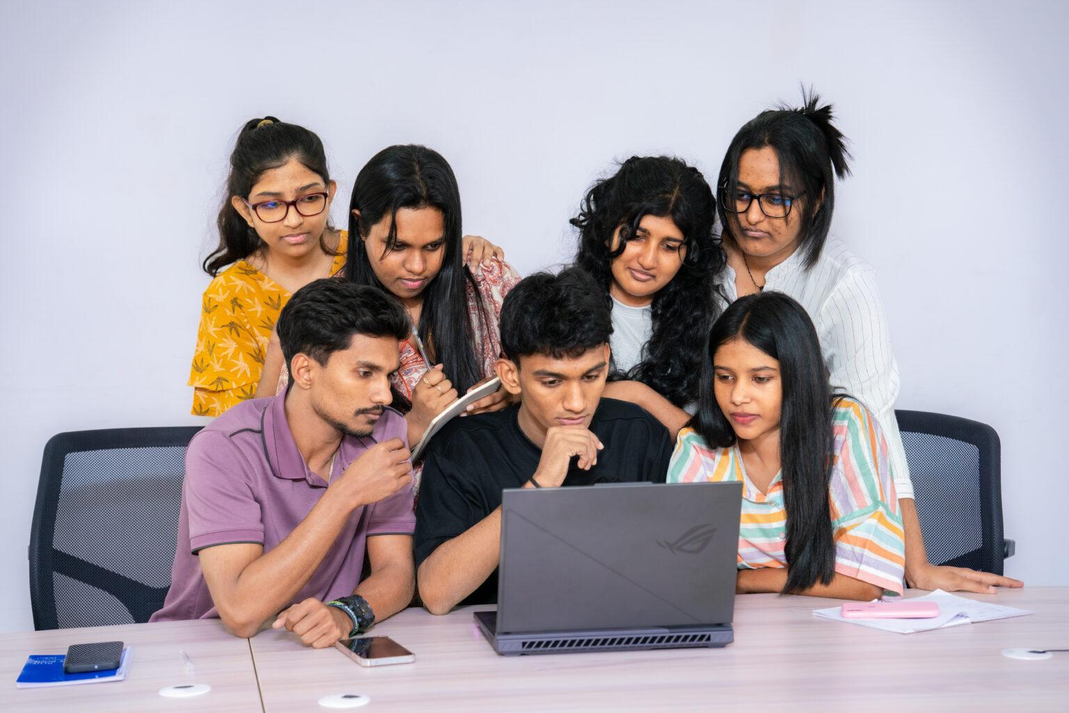 Students collaborating around a laptop
